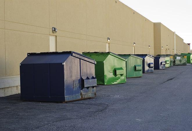 a construction worker moves construction materials near a dumpster in Colts Neck NJ